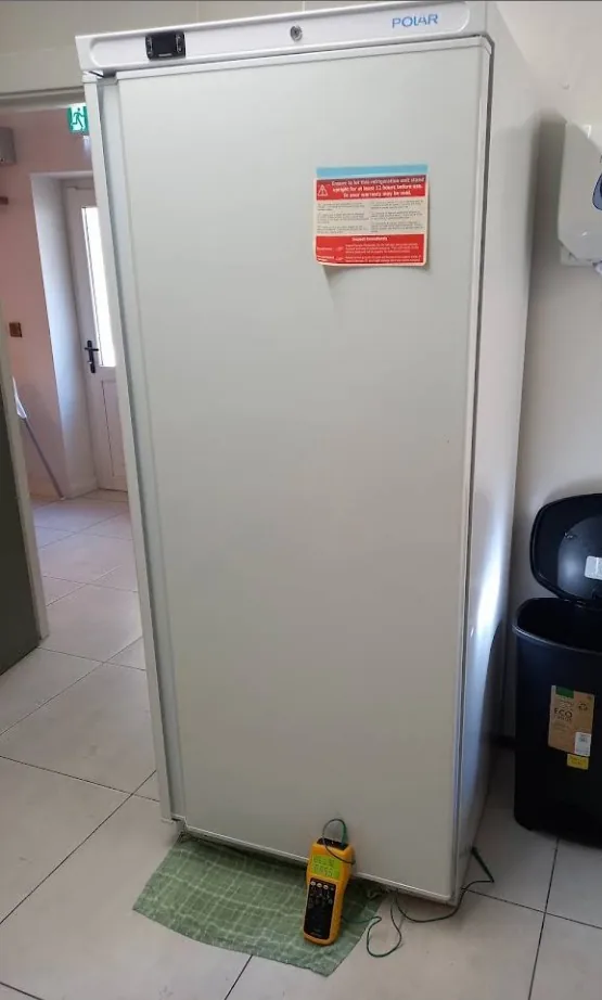 Upright commercial refrigerator being PAT tested